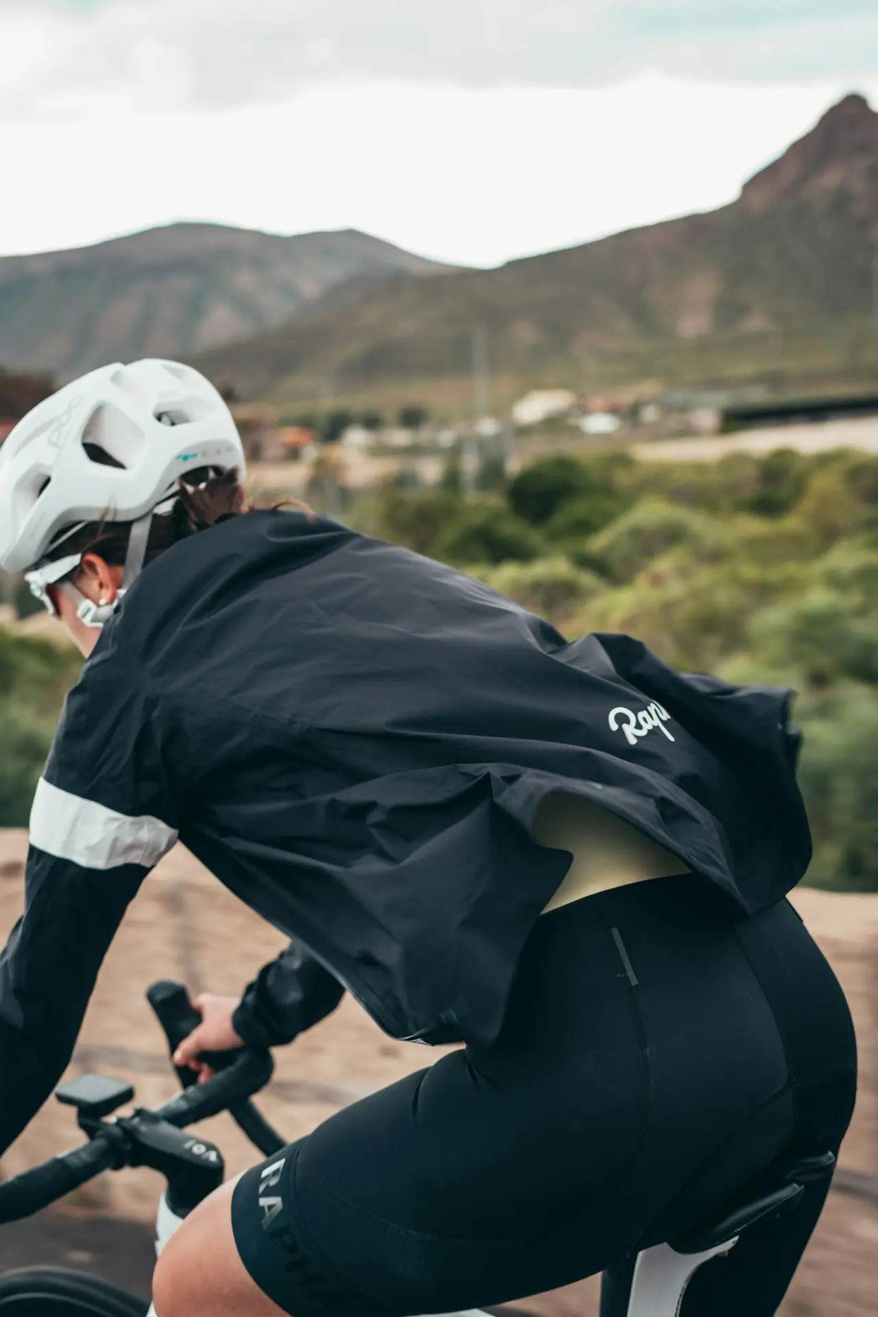 A rider climbing a dirt road on a bike.