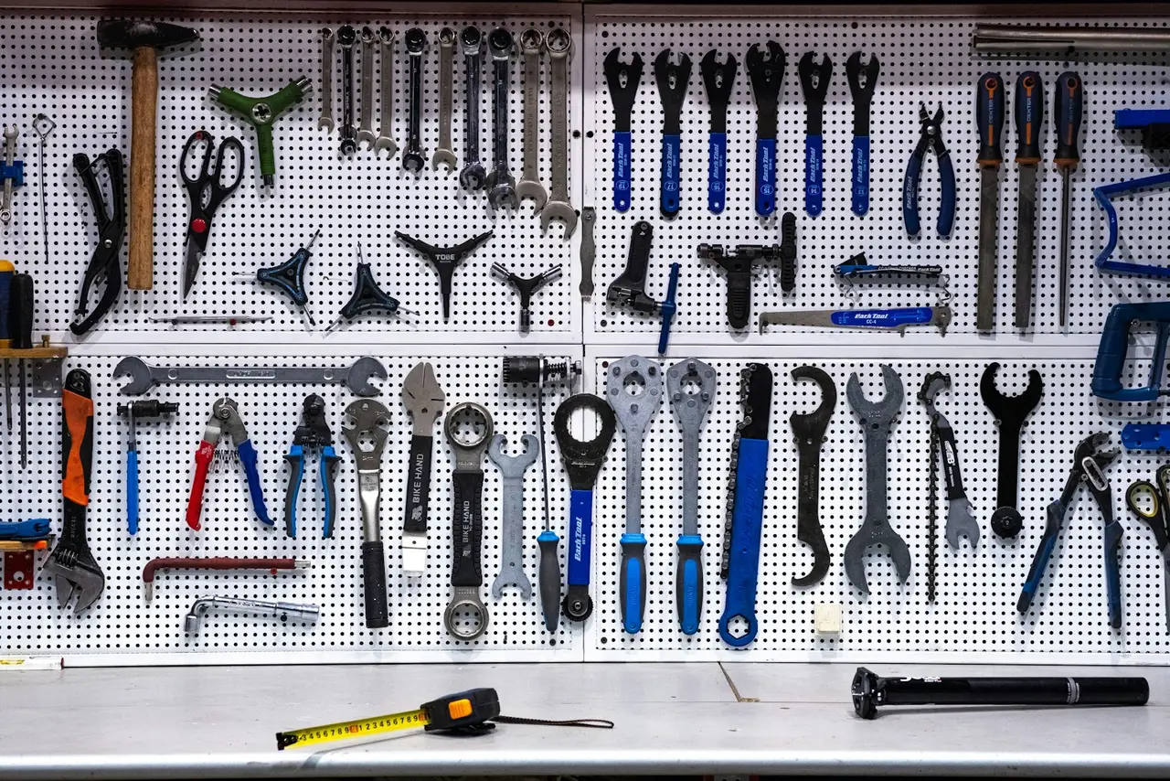A pegboard hung with neatly arranged bicycle tools.