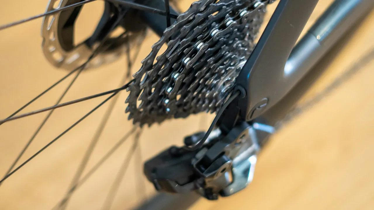 Close-up of a bicycle's rear derailleur, cassette and disc rotor.