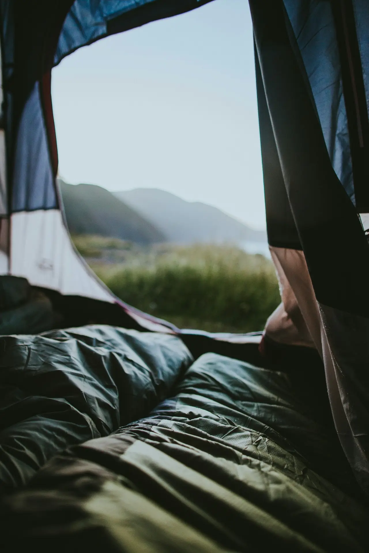 The inside of a pitched tent with bedding laid out on the floor.